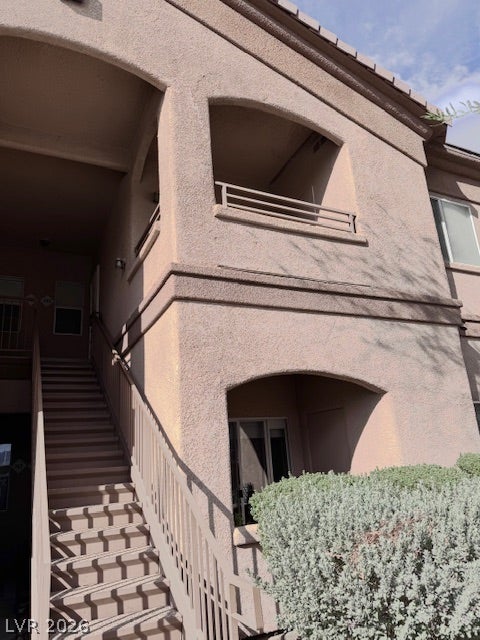Arched architectural details and stucco finishes define this multi-level exterior entryway.