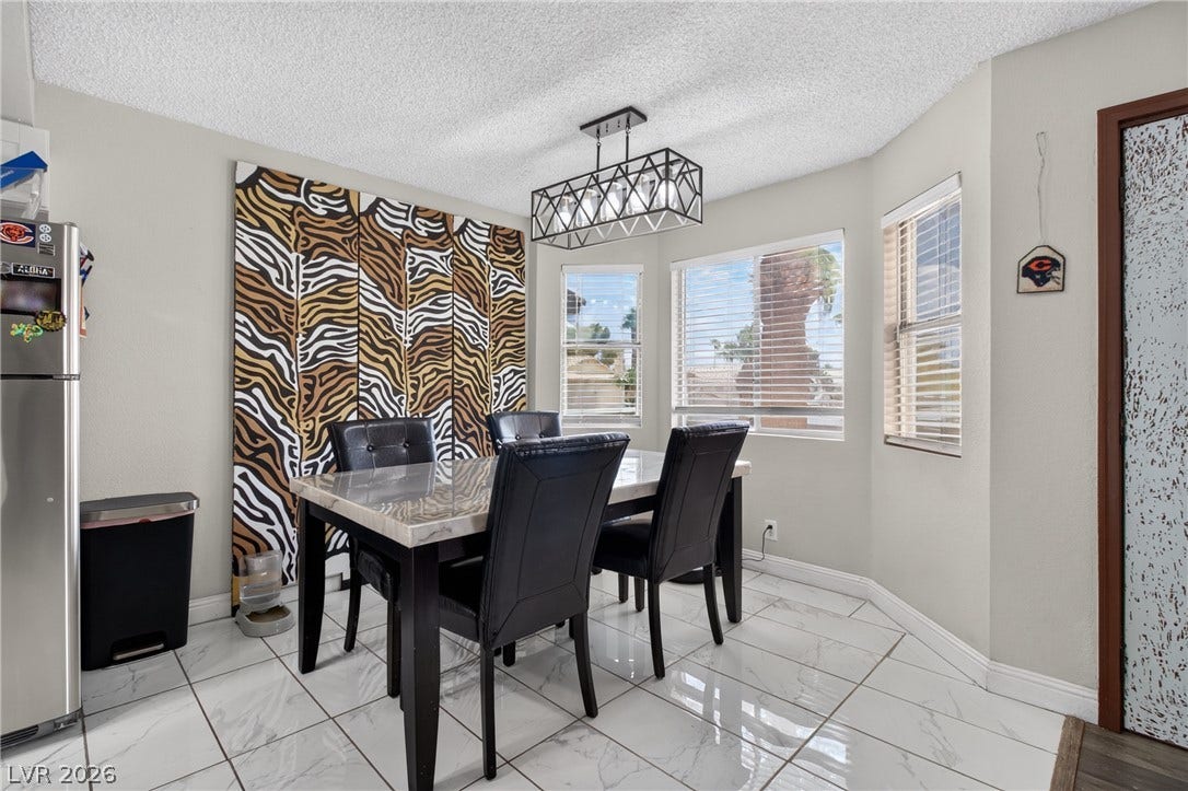 1341 Pinto Rock Lane, #202, Las Vegas, NV 89128 Gleaming tile floors and natural light from a bay window define this dining space.