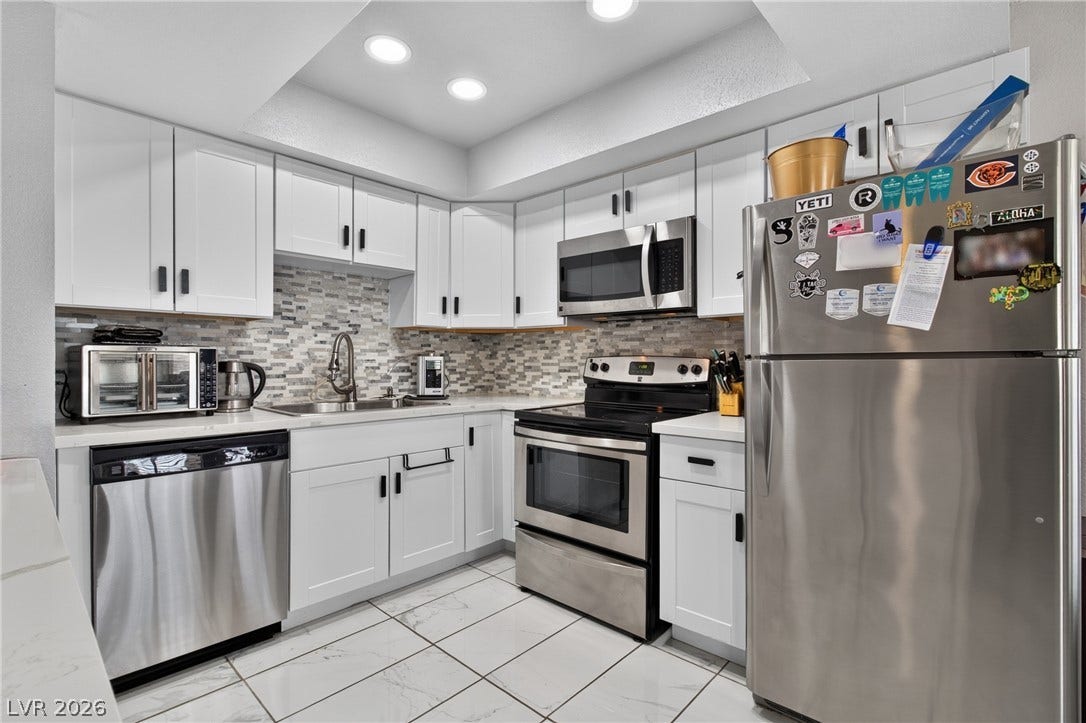 1341 Pinto Rock Lane, #202, Las Vegas, NV 89128 Gleaming tiled floors pair elegantly with shaker cabinetry and modern stainless steel appliances.