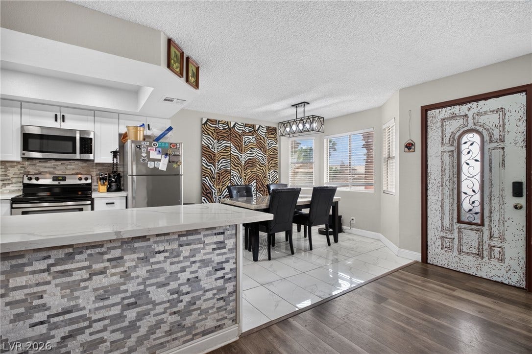 1341 Pinto Rock Lane, #202, Las Vegas, NV 89128 Gleaming tile transitions to rich wood flooring in this inviting open-concept dining space.