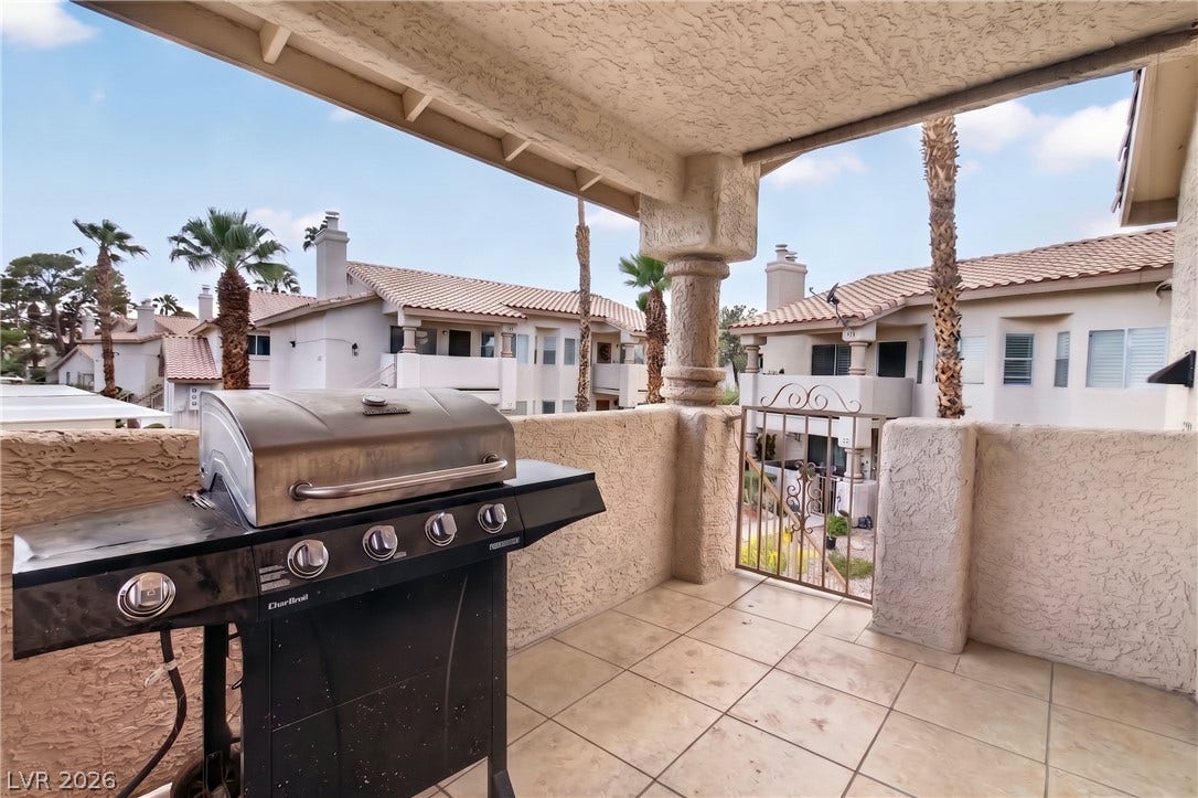 1341 Pinto Rock Lane, #202, Las Vegas, NV 89128 Tiled balcony space features a covered structure and textured stone-look railing walls.