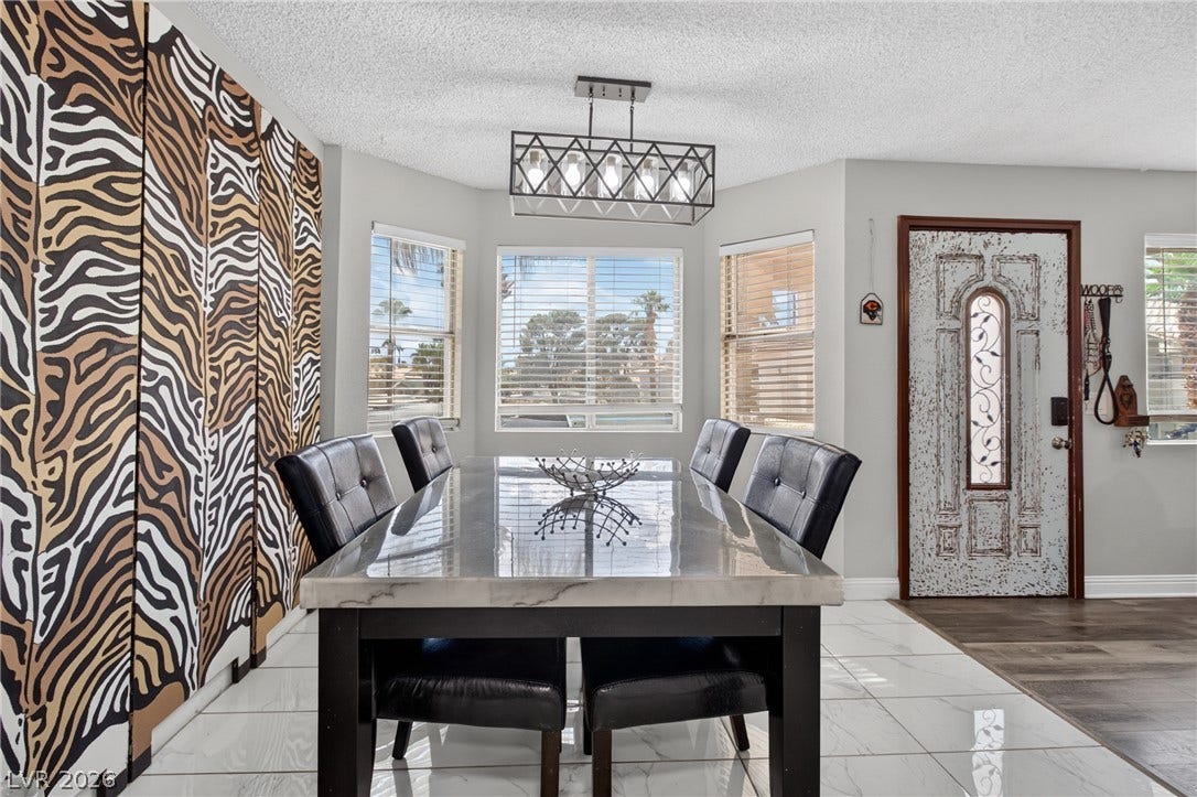 1341 Pinto Rock Lane, #202, Las Vegas, NV 89128 Polished tile flooring and multi-angled windows elevate this bright, open-plan dining space.