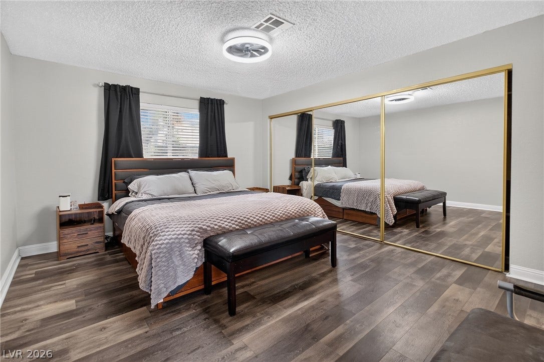 1341 Pinto Rock Lane, #202, Las Vegas, NV 89128 Smooth wood-look flooring and a large mirrored closet enrich this comfortable bedroom space.