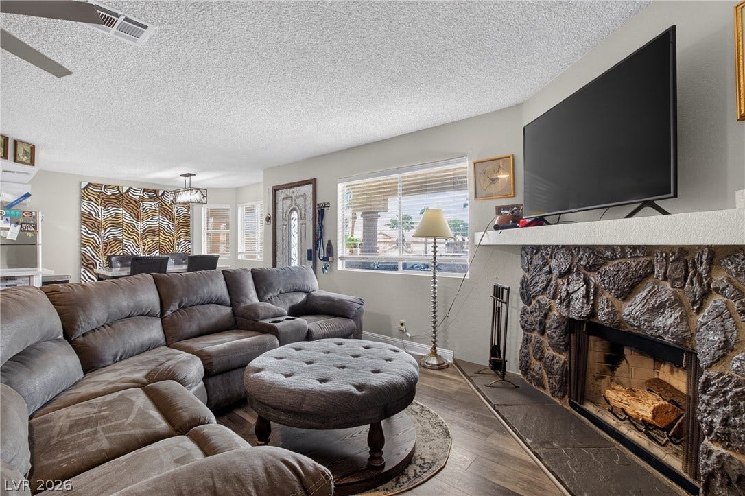 1341 Pinto Rock Lane, #202, Las Vegas, NV 89128 An inviting stone fireplace serves as the centerpiece of this open living space.