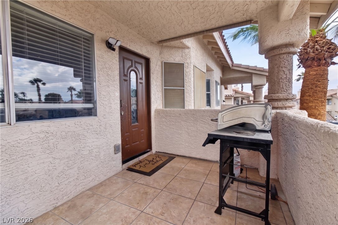 1341 Pinto Rock Lane, #202, Las Vegas, NV 89128 Tiled flooring and stucco pillars define a welcoming covered entry porch.
