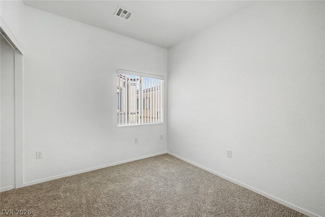 Plush carpeting and a classic sliding closet door define this versatile bedroom space.