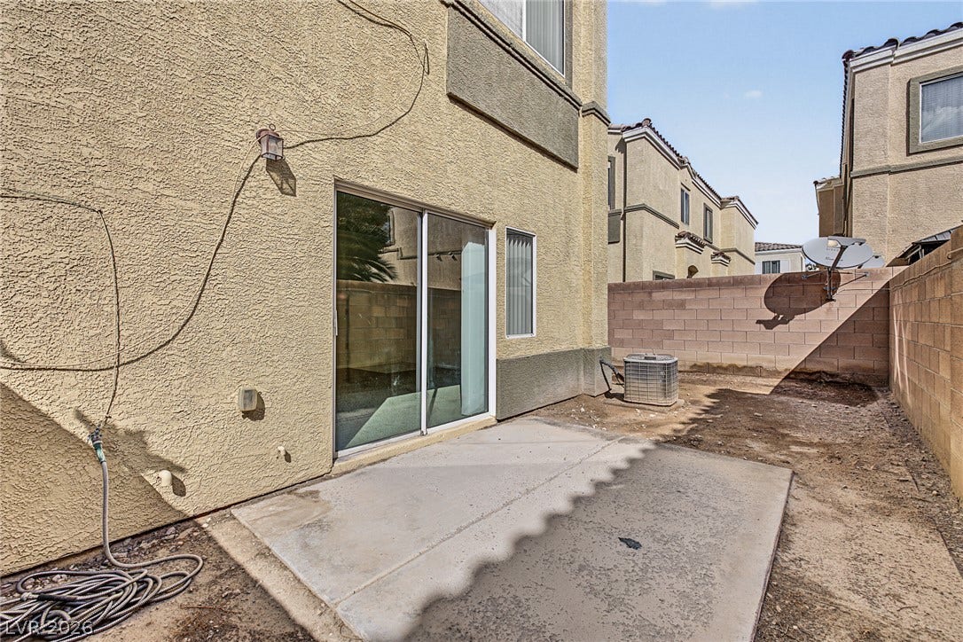 Sliding glass doors open directly to a private concrete patio area.