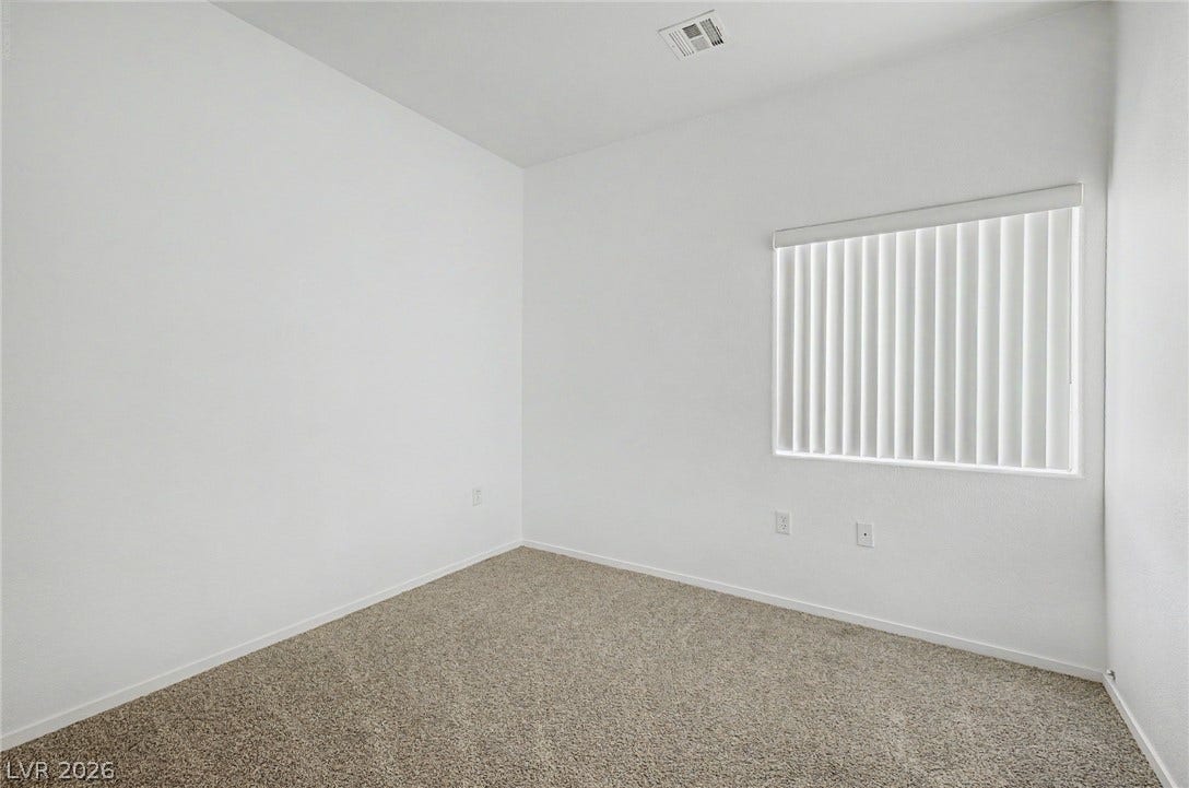 Clean lines and soft carpeting define this versatile secondary bedroom space.