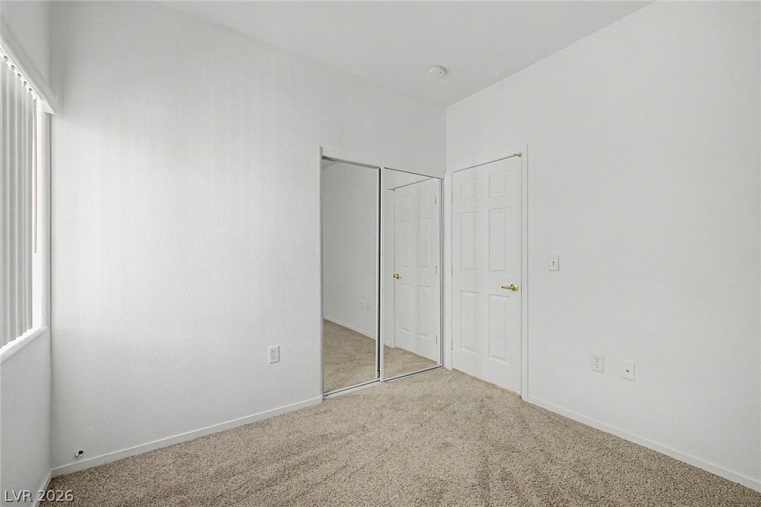 Plush carpeting and mirrored closet doors enhance this light-filled secondary bedroom.