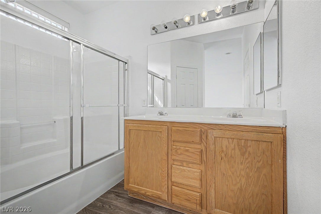An oversized vanity with double sinks complements the tub shower combination in this functional bathroom.
