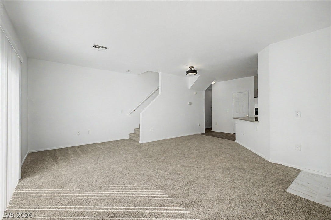 An open main-level floor plan connects the living areas under clean lines and soft carpeting.