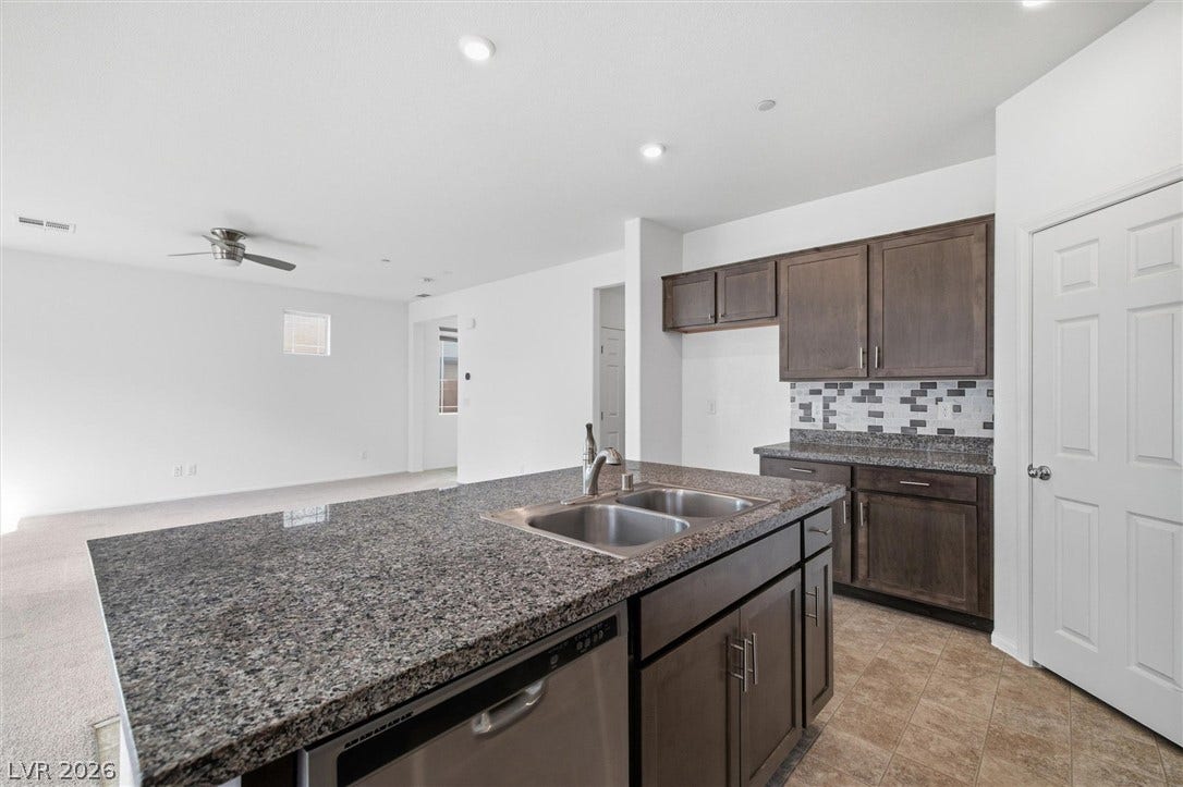 6047 Castle Gardens Avenue, Las Vegas, NV 89130 An open kitchen layout showcases durable stone counters and a spacious central island.