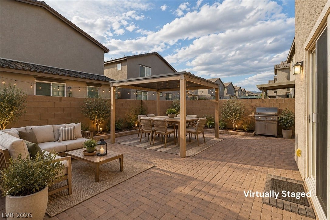 6047 Castle Gardens Avenue, Las Vegas, NV 89130 An inviting paver patio layout features a wooden pergola and sliding glass door access.