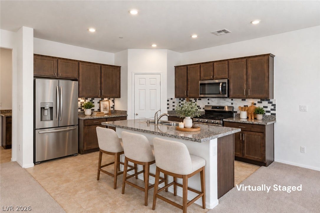 6047 Castle Gardens Avenue, Las Vegas, NV 89130 Rich wood cabinetry and polished granite countertops define this modern, open-concept cooking space.