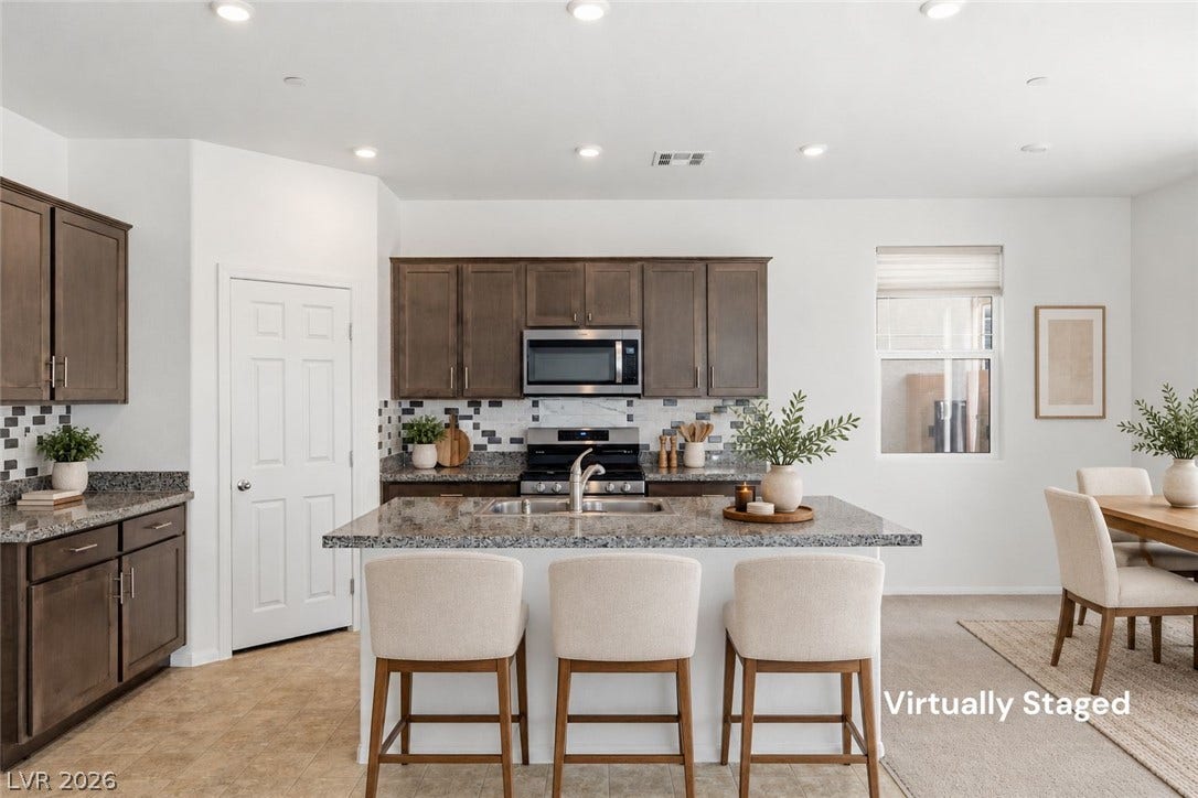 6047 Castle Gardens Avenue, Las Vegas, NV 89130 Rich wood cabinetry contrasts with premium stone countertops in this open concept kitchen design.