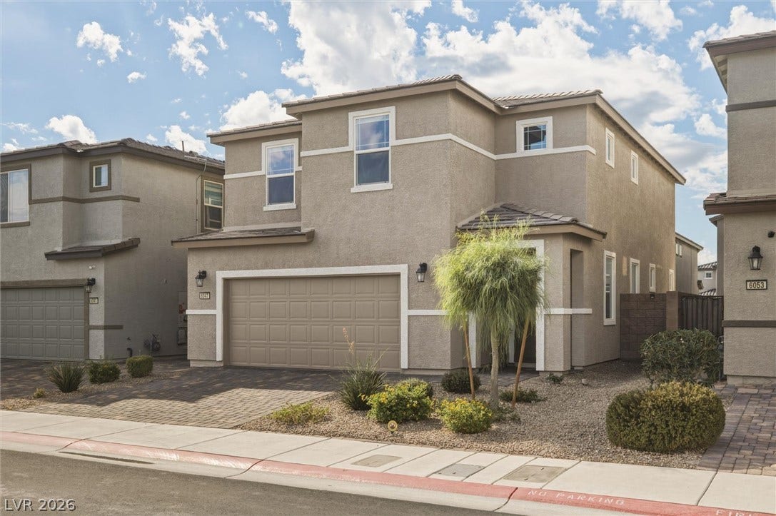 6047 Castle Gardens Avenue, Las Vegas, NV 89130 A modern two-story home displays clean lines, stucco finishes, and desert-inspired front landscaping.