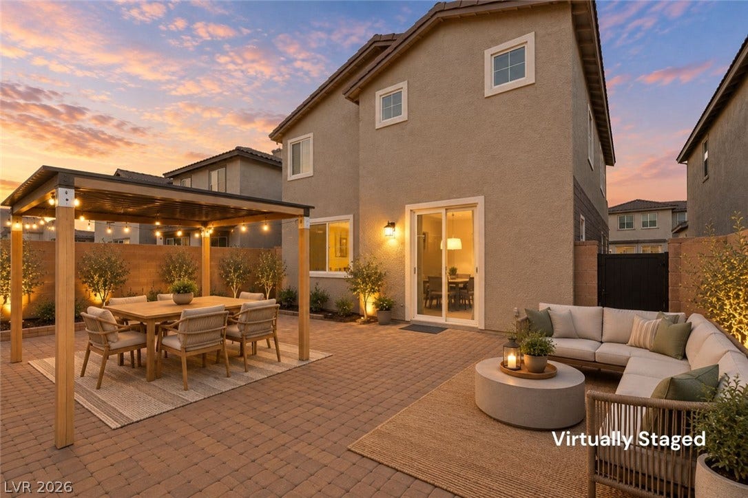 6047 Castle Gardens Avenue, Las Vegas, NV 89130 An inviting paver courtyard features a wooden pergola structure under a warm twilight sky.