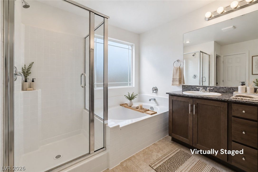 6047 Castle Gardens Avenue, Las Vegas, NV 89130 A glass-enclosed shower, deep soaking tub, and granite-topped vanity anchor this comfortable bathroom.
