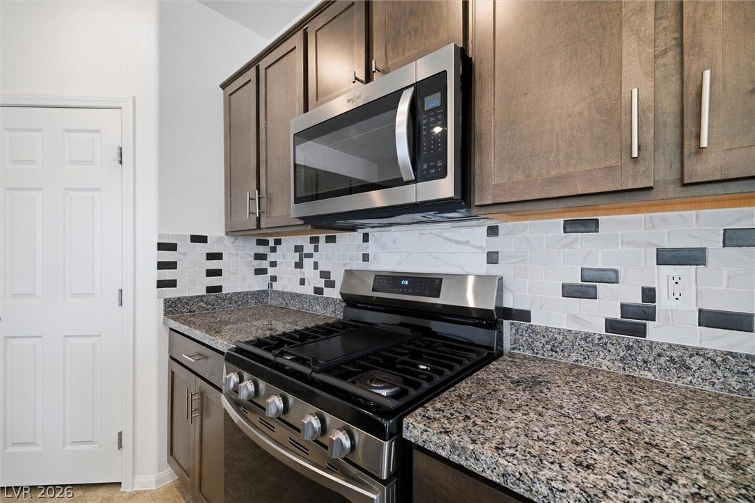 6047 Castle Gardens Avenue, Las Vegas, NV 89130 Gleaming granite countertops pair beautifully with custom wood cabinetry and modern stainless steel appliances.