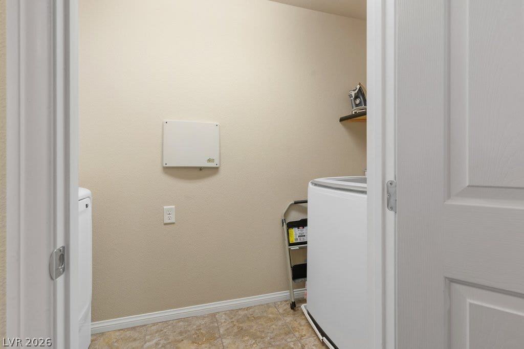 8430 Golden Amber Street, Las Vegas, NV 89139 Functional laundry space includes durable tile flooring and overhead storage shelving.