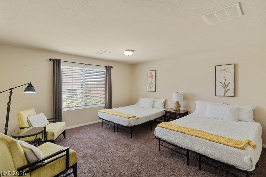 8430 Golden Amber Street, Las Vegas, NV 89139 Plush carpeting anchors this spacious bedroom featuring a wide window that draws in natural light.