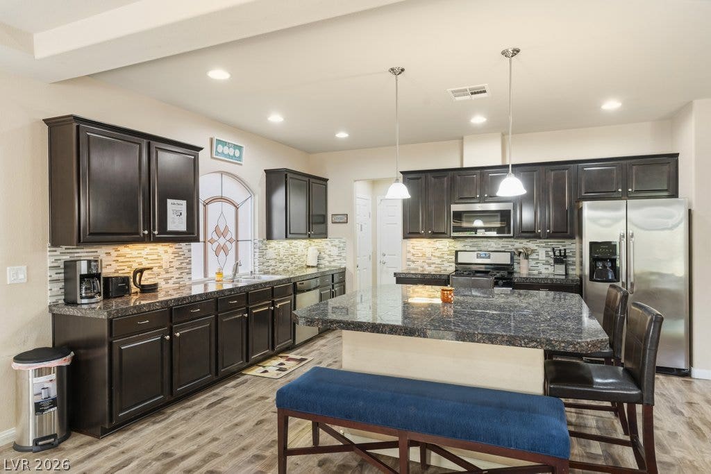 8430 Golden Amber Street, Las Vegas, NV 89139 Dark cabinetry and granite countertops define this functional culinary space with center island breakfast bar.