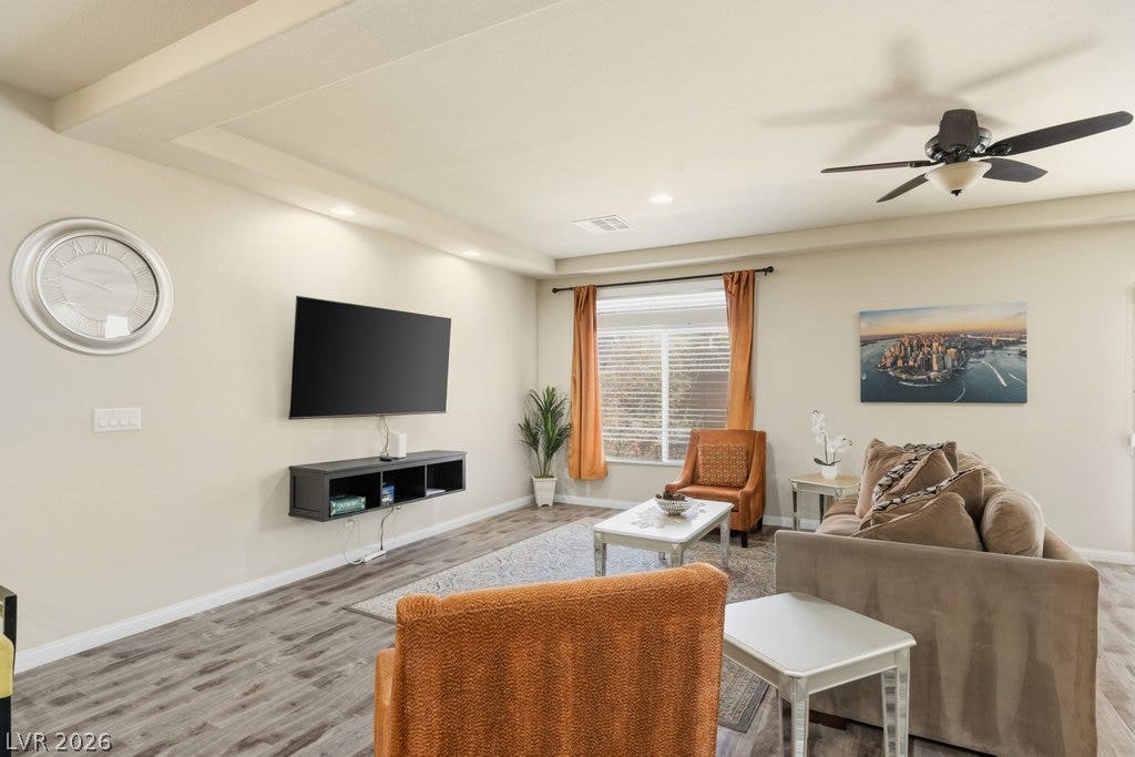 8430 Golden Amber Street, Las Vegas, NV 89139 A spacious living area features recessed lighting and smooth wood-style flooring.