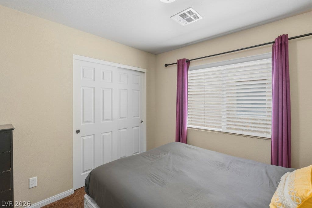 8430 Golden Amber Street, Las Vegas, NV 89139 Plentiful natural light filters through a wide window highlighting the neutral-toned bedroom walls.