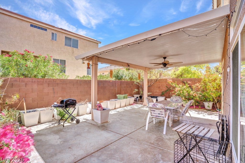 8430 Golden Amber Street, Las Vegas, NV 89139 An inviting covered patio offers a spacious outdoor concrete surface framed by mature landscaping.
