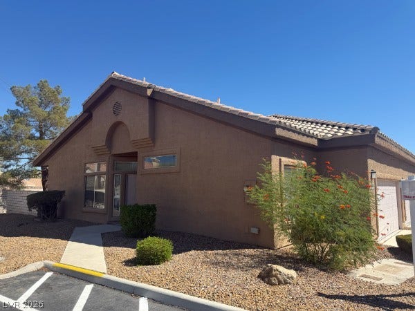 Classic desert landscaping accents the stucco exterior and tiled roof of this inviting single-story home.