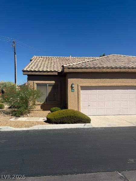 A classic tile roof and stucco exterior define this desert-landscaped residence.
