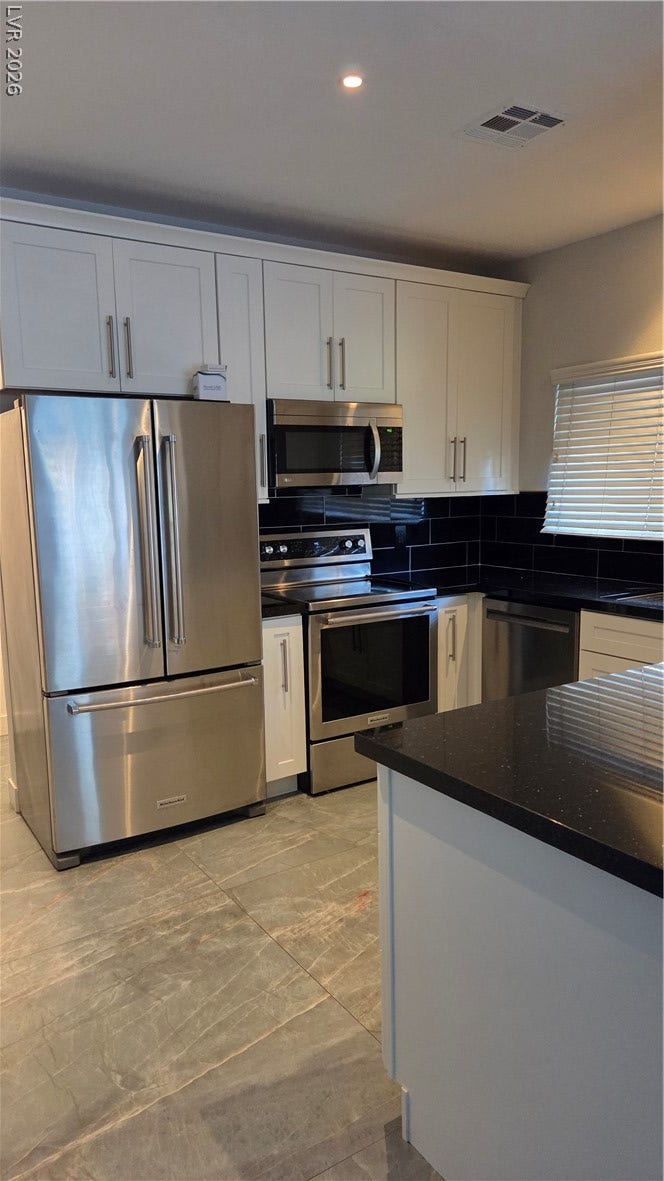 2619 Red Rock Street, #101, Las Vegas, NV 89146 Gleaming stone countertops and matching cabinetry elevate this modern kitchen layout.