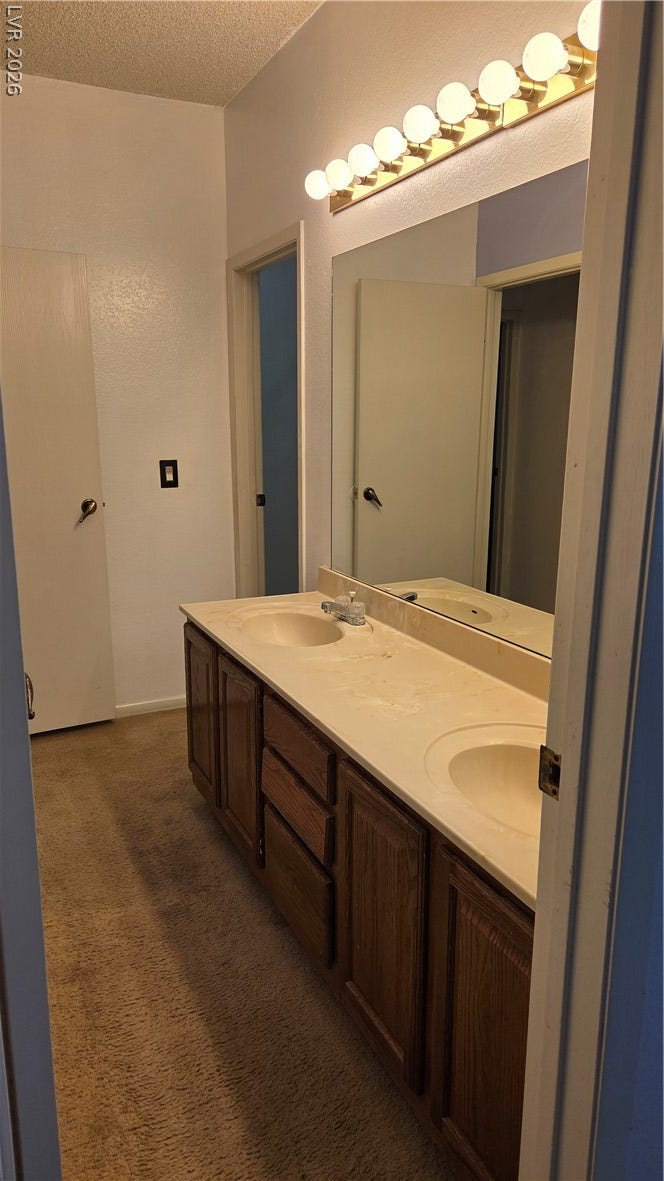 2619 Red Rock Street, #101, Las Vegas, NV 89146 Double sinks and a large vanity mirror complete this functional bathroom space.