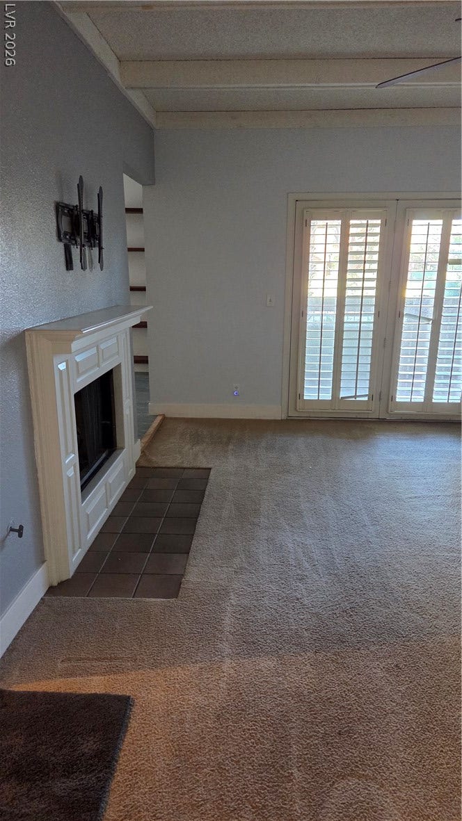 2619 Red Rock Street, #101, Las Vegas, NV 89146 A classic fireplace and beamed ceiling define this comfortable living area.