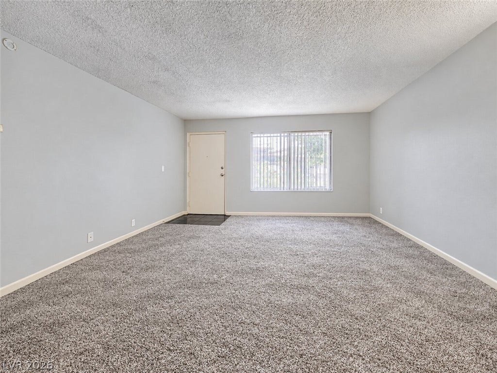 615 S Royal Crest Circle, #16, Las Vegas, NV 89169 An open living space features plush wall-to-wall carpeting and a wide window.
