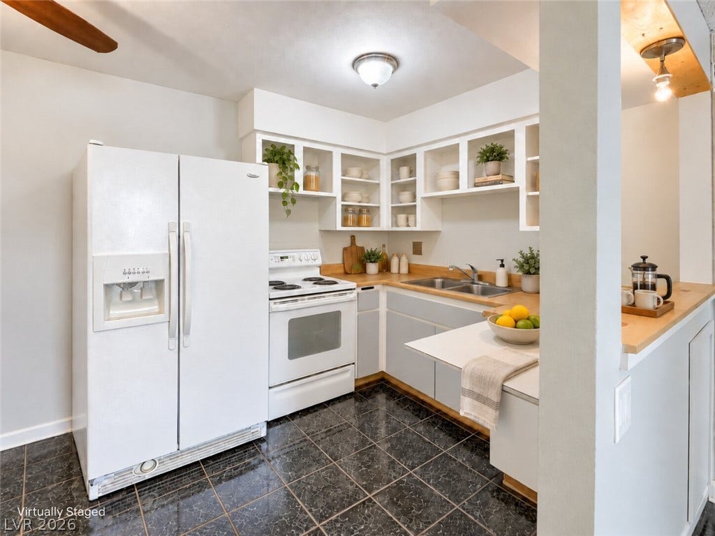 615 S Royal Crest Circle, #16, Las Vegas, NV 89169 Gleaming dark tile flooring contrasts beautifully with classic white cabinetry in this functional layout.