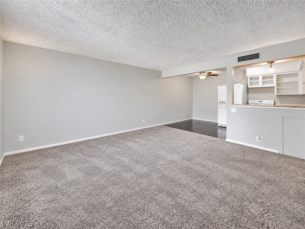 615 S Royal Crest Circle, #16, Las Vegas, NV 89169 Plush carpeting and an open-concept layout define this versatile living area.