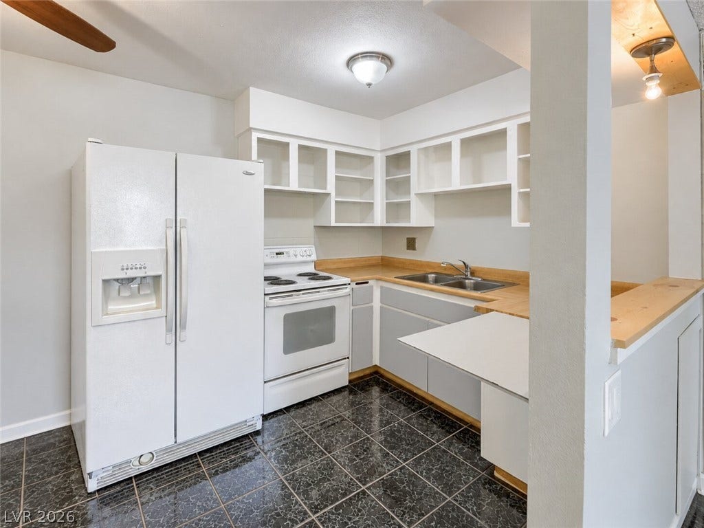 615 S Royal Crest Circle, #16, Las Vegas, NV 89169 Functional layout highlights this classic culinary space with abundant open shelving and dark tiled floors.