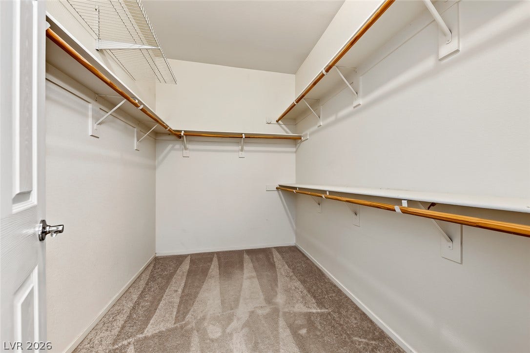 2906 Pumpkin Harvest Avenue, North Las Vegas, NV 89031 Ample built-in shelving and hanging rods maximize storage in this carpeted walk-in closet.