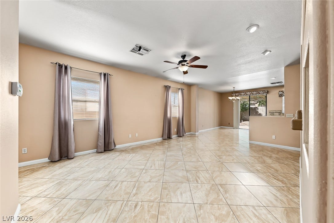2906 Pumpkin Harvest Avenue, North Las Vegas, NV 89031 Polished tile flooring flows through a versatile, light-filled living area designed for easy living.