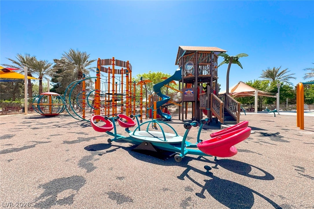 2906 Pumpkin Harvest Avenue, North Las Vegas, NV 89031 An expansive community playground features multi-level play structures under a bright blue sky.
