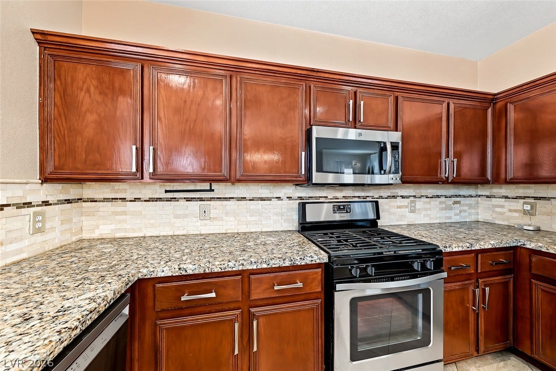 2906 Pumpkin Harvest Avenue, North Las Vegas, NV 89031 Rich wood cabinets and granite countertops define this well-appointed cooking space.