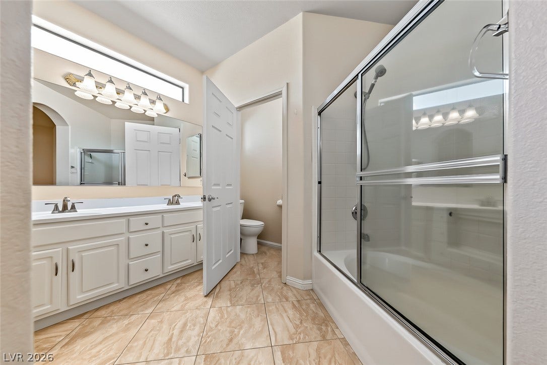 2906 Pumpkin Harvest Avenue, North Las Vegas, NV 89031 A spacious vanity and sliding glass tub doors define this functional bathroom layout.