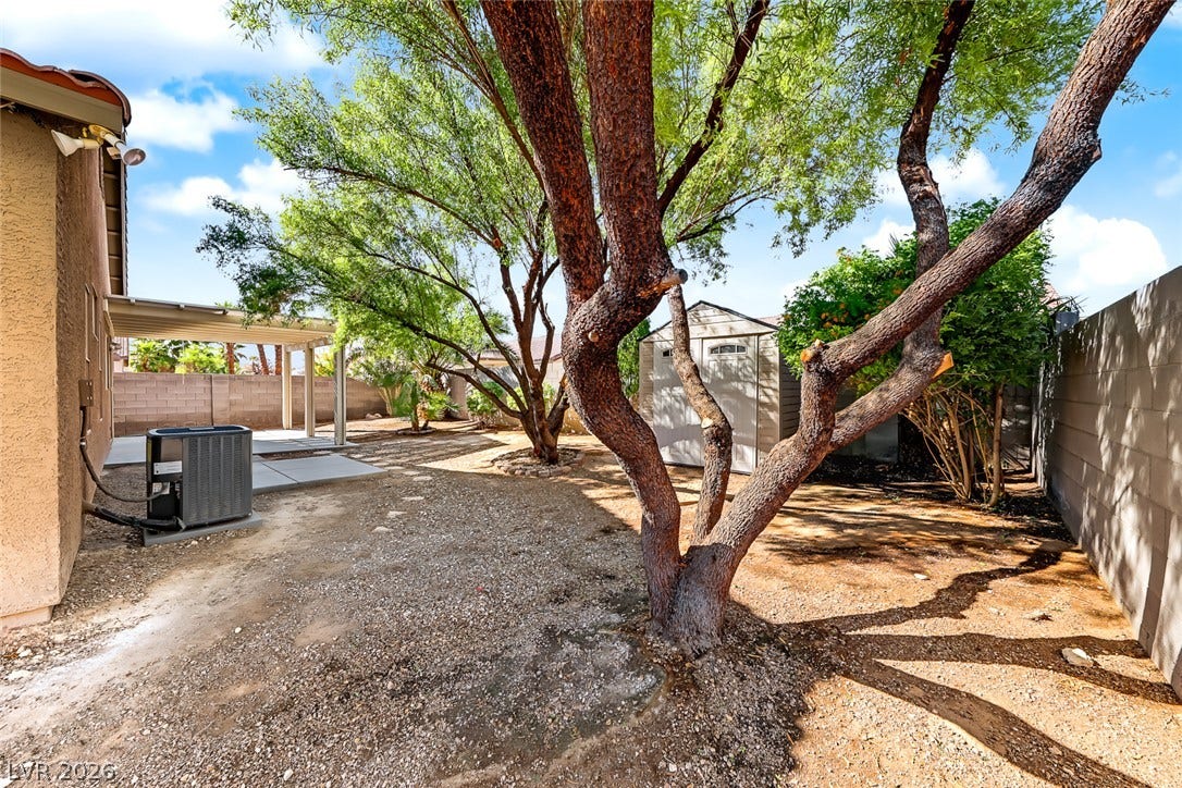 2906 Pumpkin Harvest Avenue, North Las Vegas, NV 89031 Mature trees shade a low-maintenance backyard enclosed by block walls.