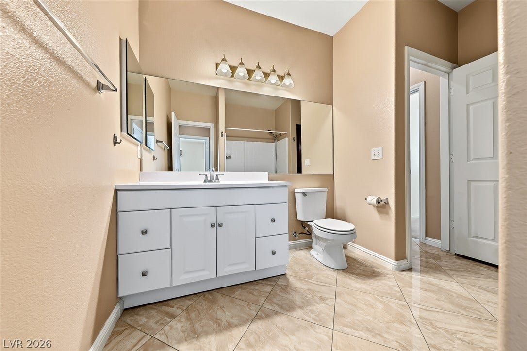 2906 Pumpkin Harvest Avenue, North Las Vegas, NV 89031 High ceilings and neutral tile flooring complement this well-appointed bathroom space.