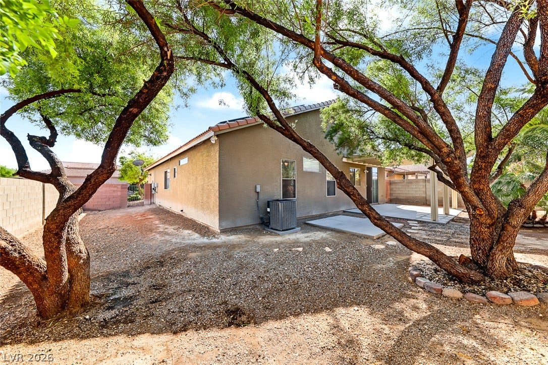 2906 Pumpkin Harvest Avenue, North Las Vegas, NV 89031 Mature trees shade a low-maintenance backyard complete with a concrete patio.