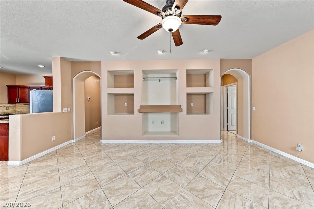 2906 Pumpkin Harvest Avenue, North Las Vegas, NV 89031 Gleaming tile floors and arched doorways accent this open living area featuring integrated media shelving.