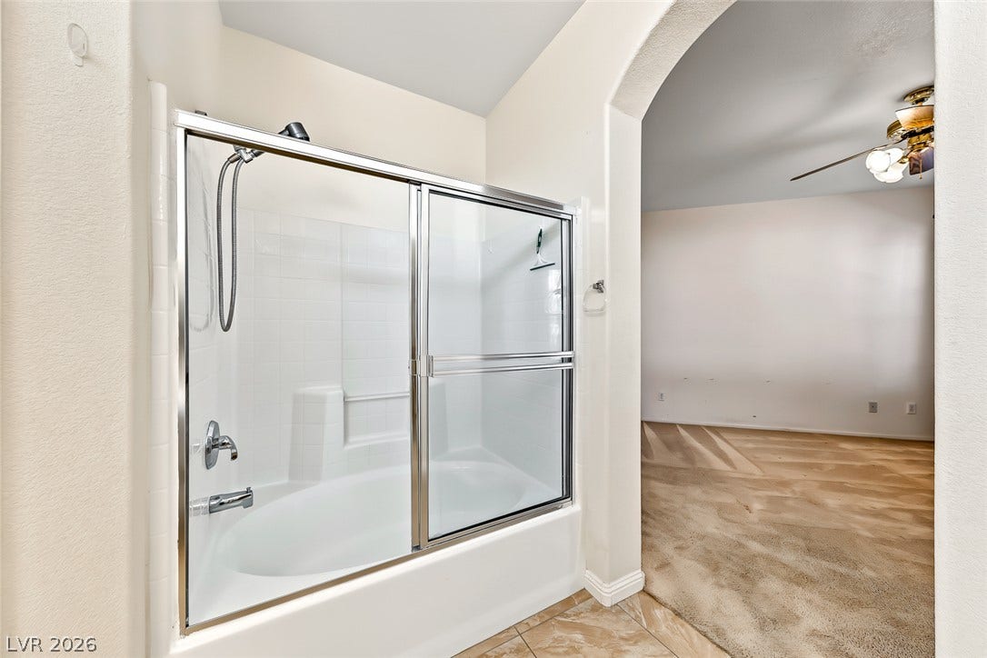 2906 Pumpkin Harvest Avenue, North Las Vegas, NV 89031 An arched doorway leads from the tiled bathroom with a tub-shower combo to carpeted living areas.