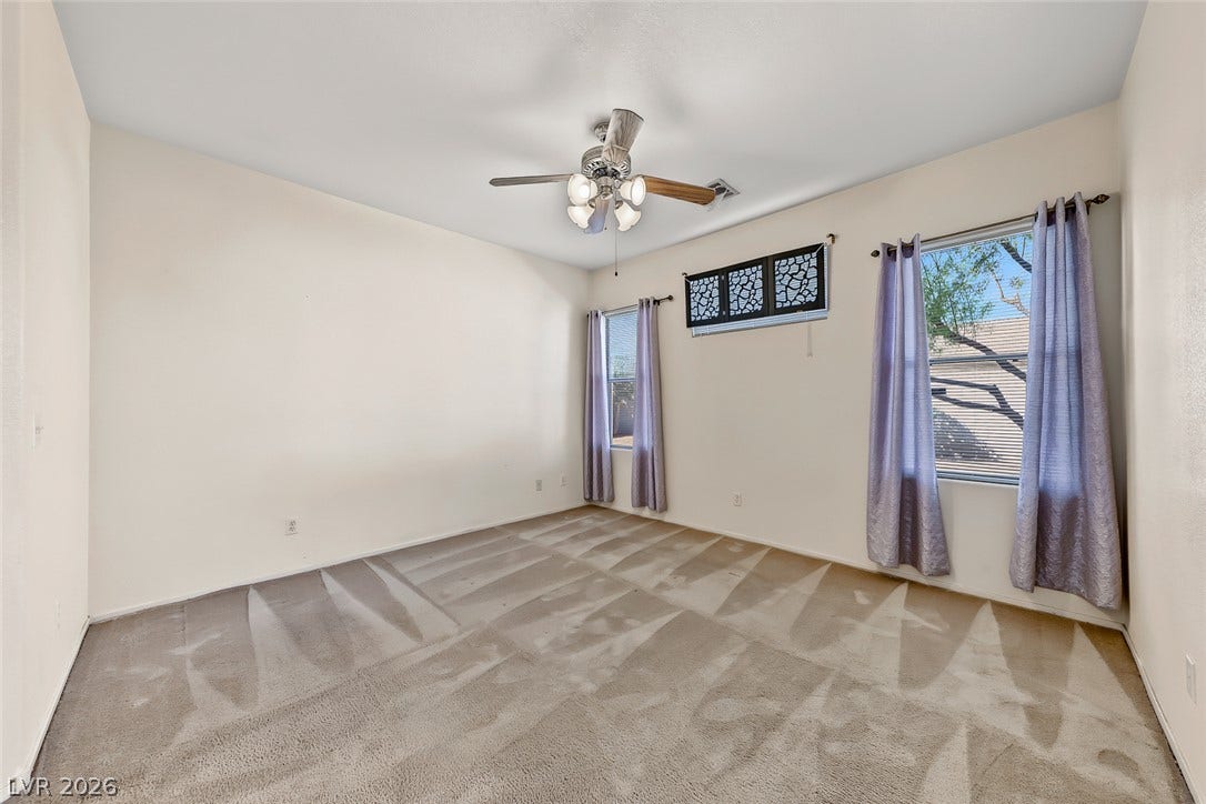 2906 Pumpkin Harvest Avenue, North Las Vegas, NV 89031 Generous windows fill this carpeted bedroom with natural light.