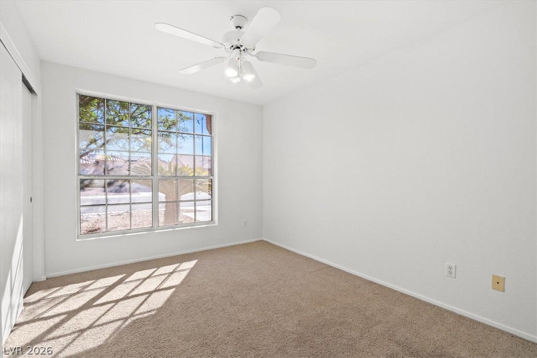3535 Barrel Bronco Court, North Las Vegas, NV 89032 Natural light streams through a large window, illuminating this comfortable carpeted bedroom.